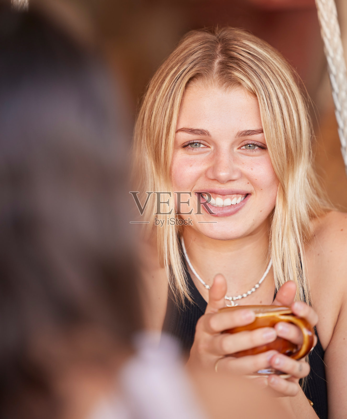 女人，朋友和微笑着喝咖啡，聊天或在户外咖啡馆谈论社会生活或八卦。快乐的女性微笑着为温暖的饮料，讨论或与最好的朋友交谈照片摄影图片