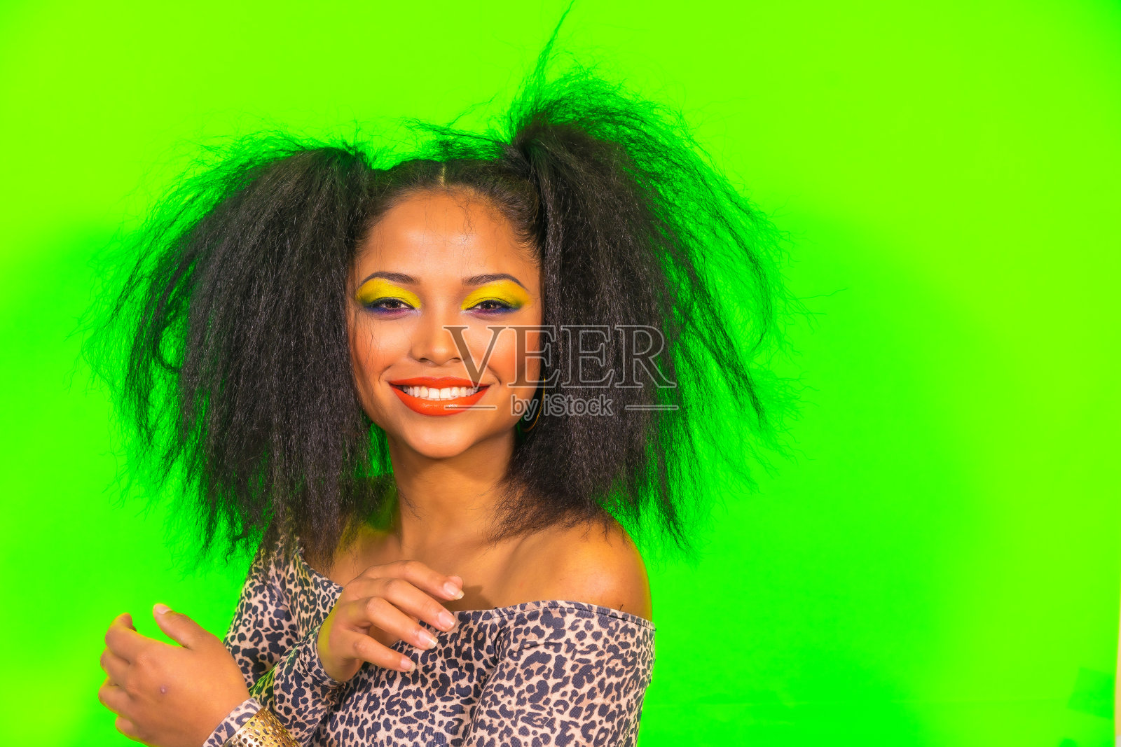 积极的年轻潮女孩明亮的妆容和两个尾巴的发型，穿着豹纹连衣裙照片摄影图片