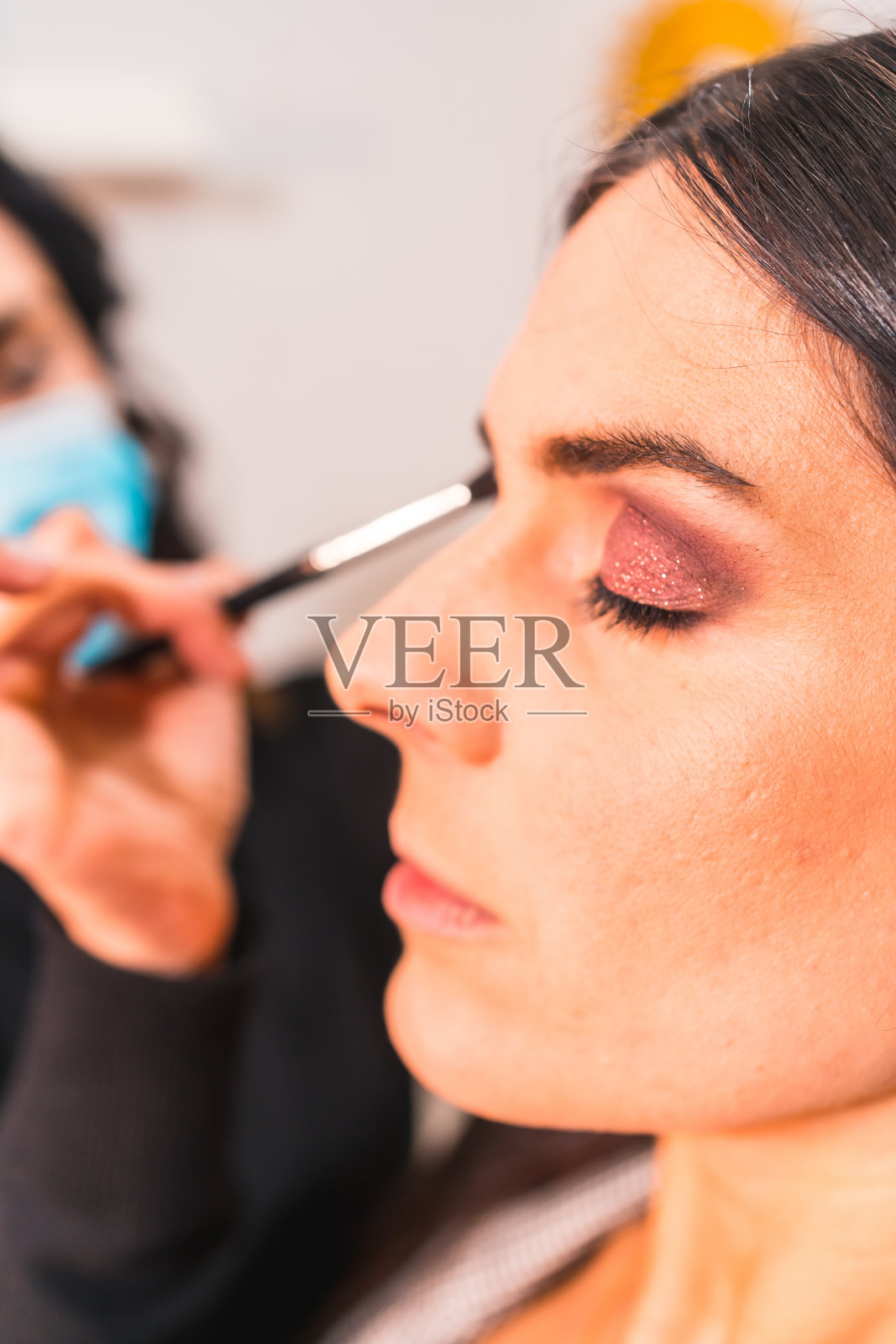 在美容院工作的带着防护面具的化妆师照片摄影图片