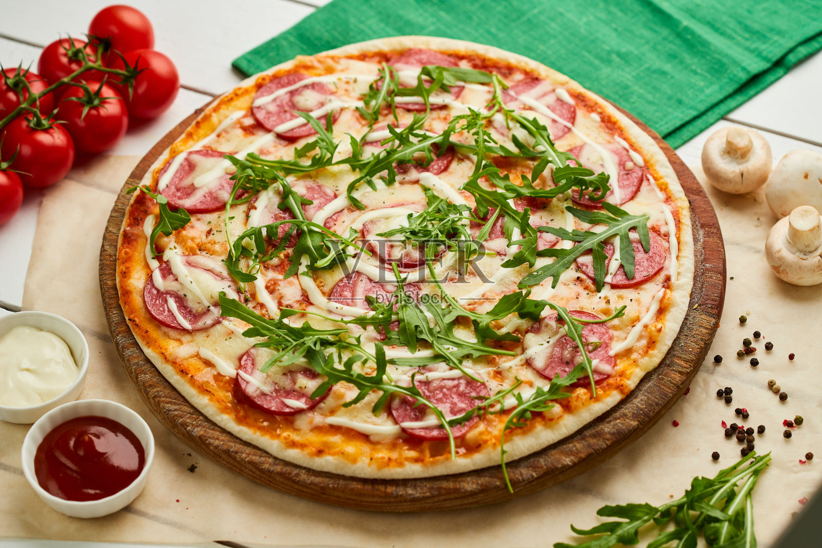 新鲜出炉的美味意大利辣香肠披萨配意大利腊肠、马苏里拉芝士和鲁可拉，配以番茄、酱汁和香草。外卖概念。餐厅的菜单照片摄影图片