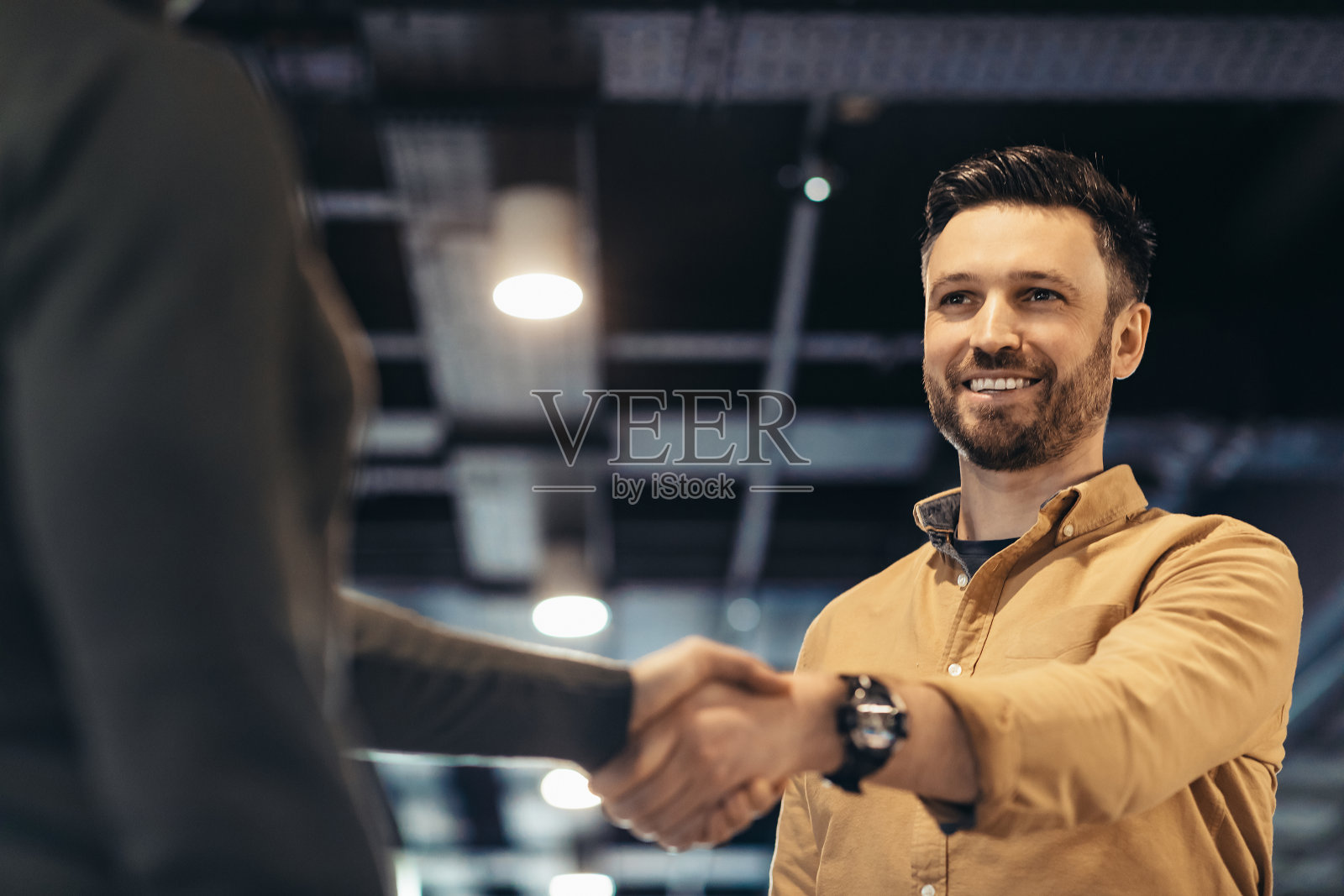 在办公楼签订合同后，积极的商人与合作伙伴握手。合伙、商业协议照片摄影图片