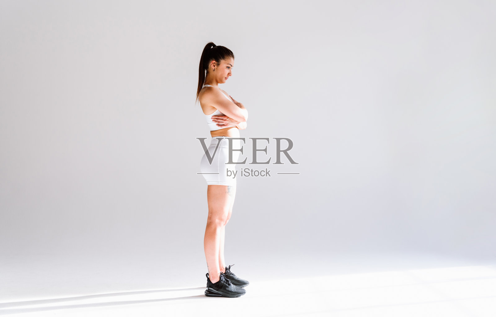 年轻的女运动员在健身房使用运动器材训练照片摄影图片