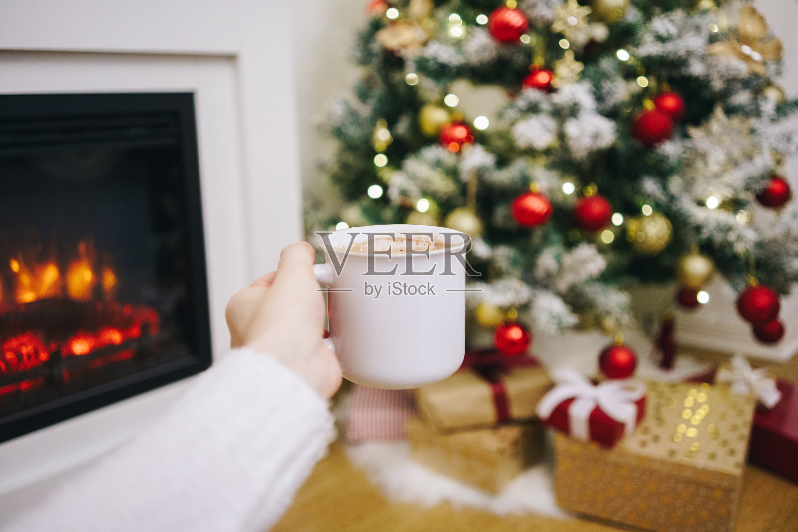 个人观点-女人在圣诞树前喝热巧克力照片摄影图片