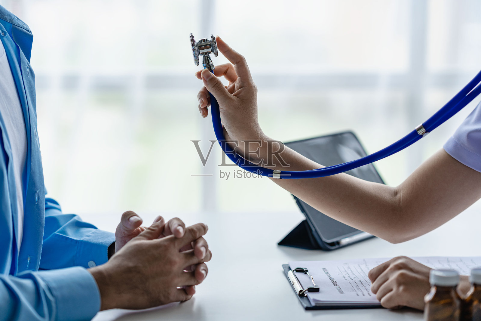 男医生在家访时手持听诊器照顾病人，医生检查心跳，检查心脏病患者，心脏病概念照片摄影图片