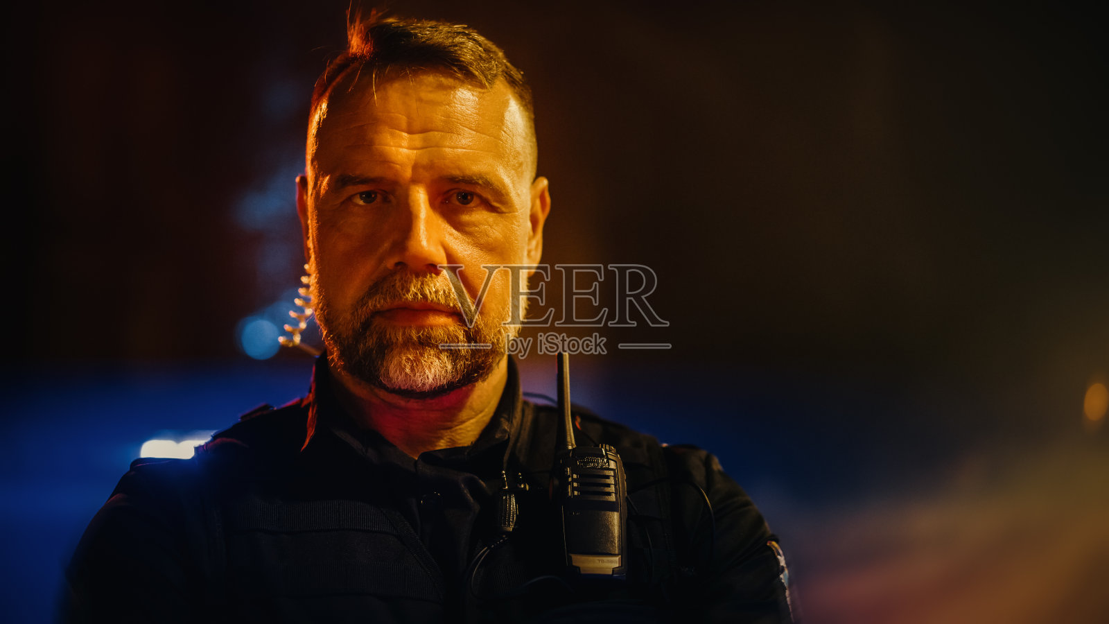 职业白人男性警察交叉双臂，摆姿势，看着相机的肖像。英勇的执勤警官，保护公民和平民的安全，打击犯罪照片摄影图片