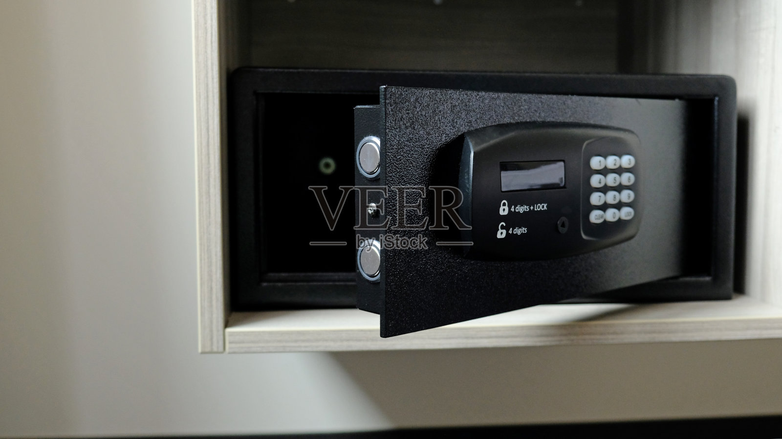 壁橱里的金属保险箱。旅馆里用来存放金钱或贵重物品的窄小的保险箱。用输入密码的按钮打开保险门。紧凑的保险箱内柜。有选择性的重点。照片摄影图片