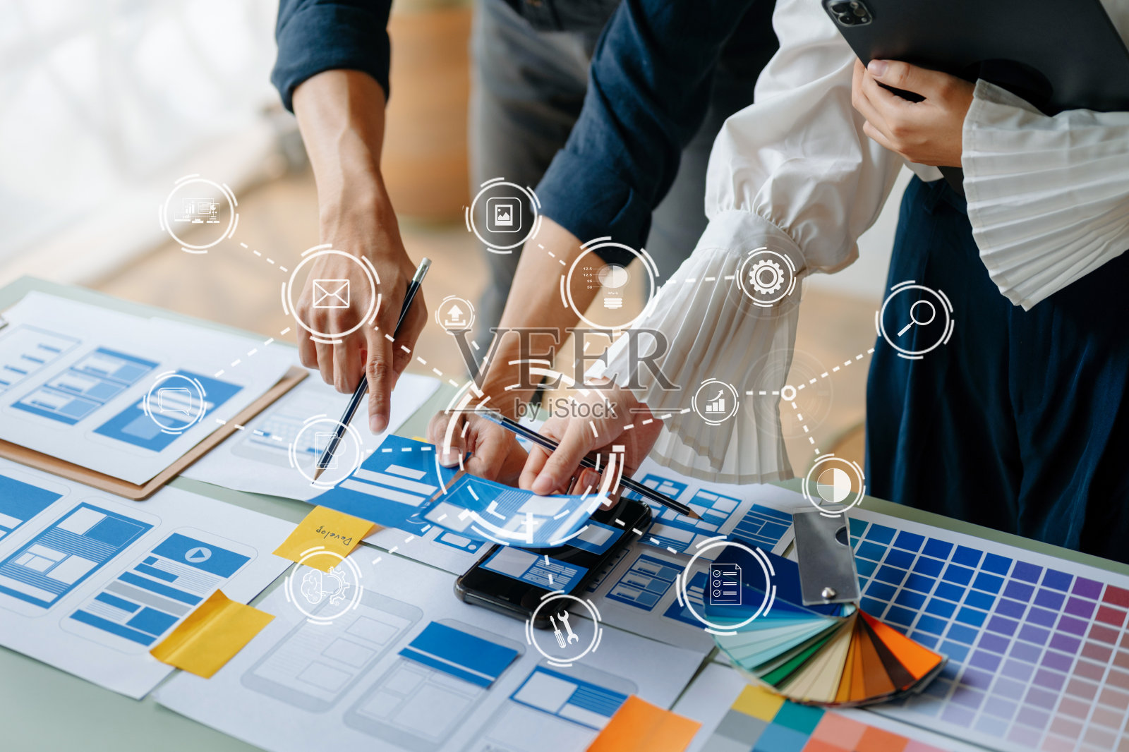 UI开发团队头脑风暴他们的项目与笔记本电脑，智能手机和数字平板电脑的观点。创意数字发展机构。照片摄影图片