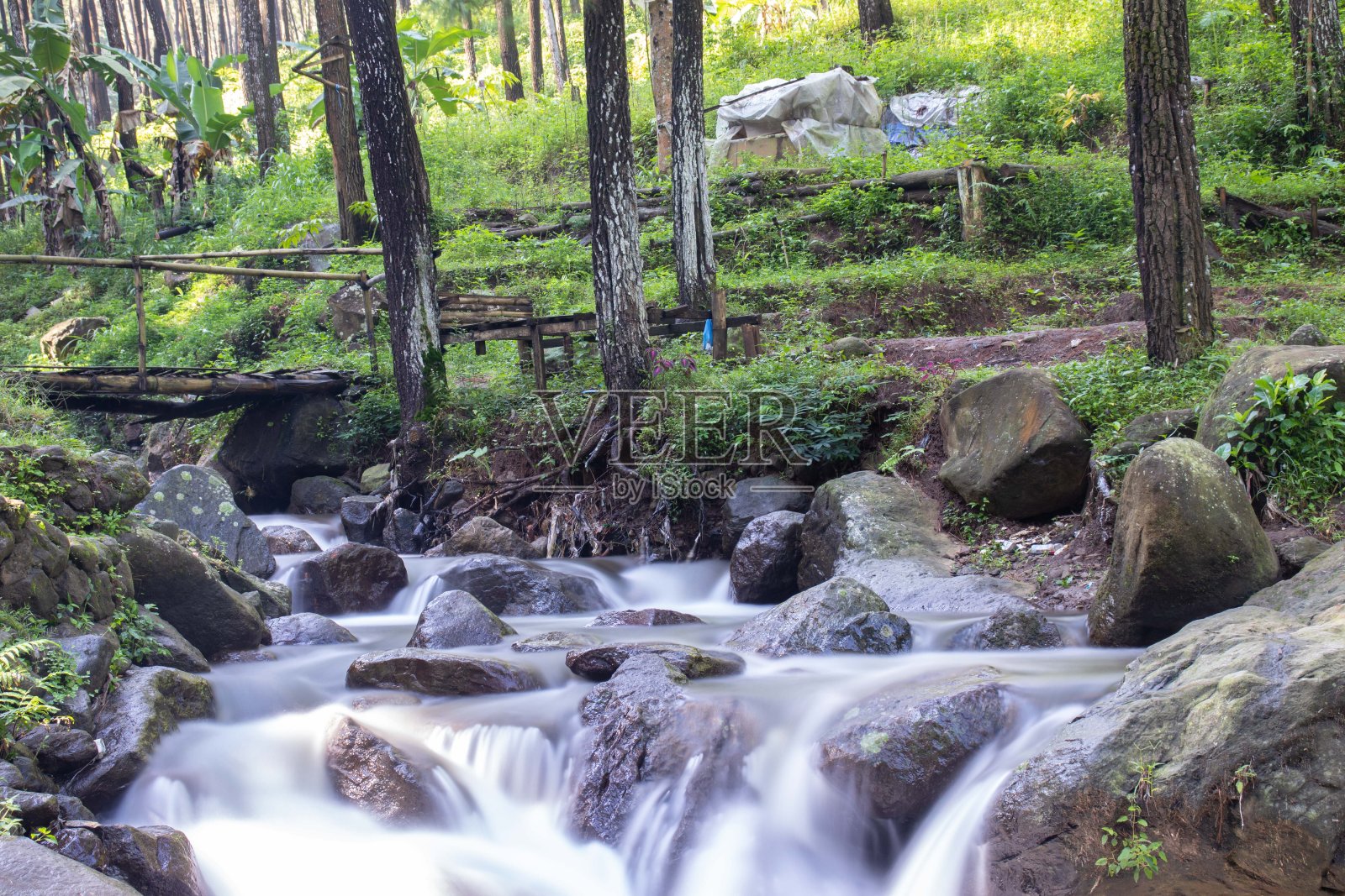 美丽的河流在热带雨林环绕的群山中流淌照片摄影图片
