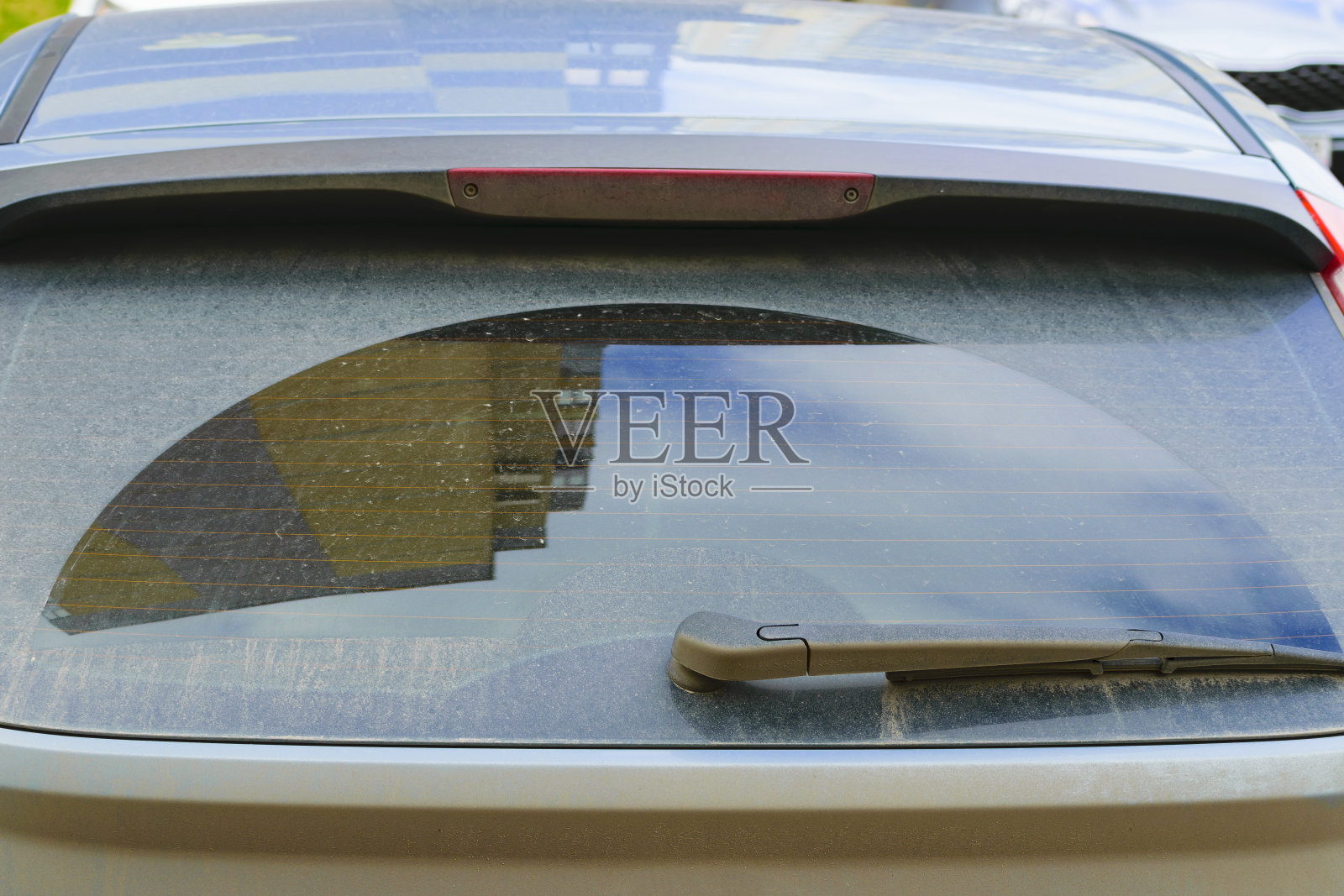 汽车后窗脏了。后雨刷。建筑在玻璃上的倒影。特写镜头照片摄影图片