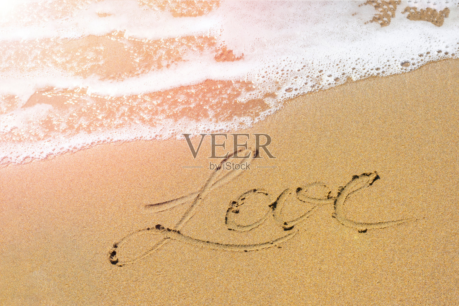 地中海岸边的黄沙，带着泡沫的浪花和写着爱的文字。照片摄影图片