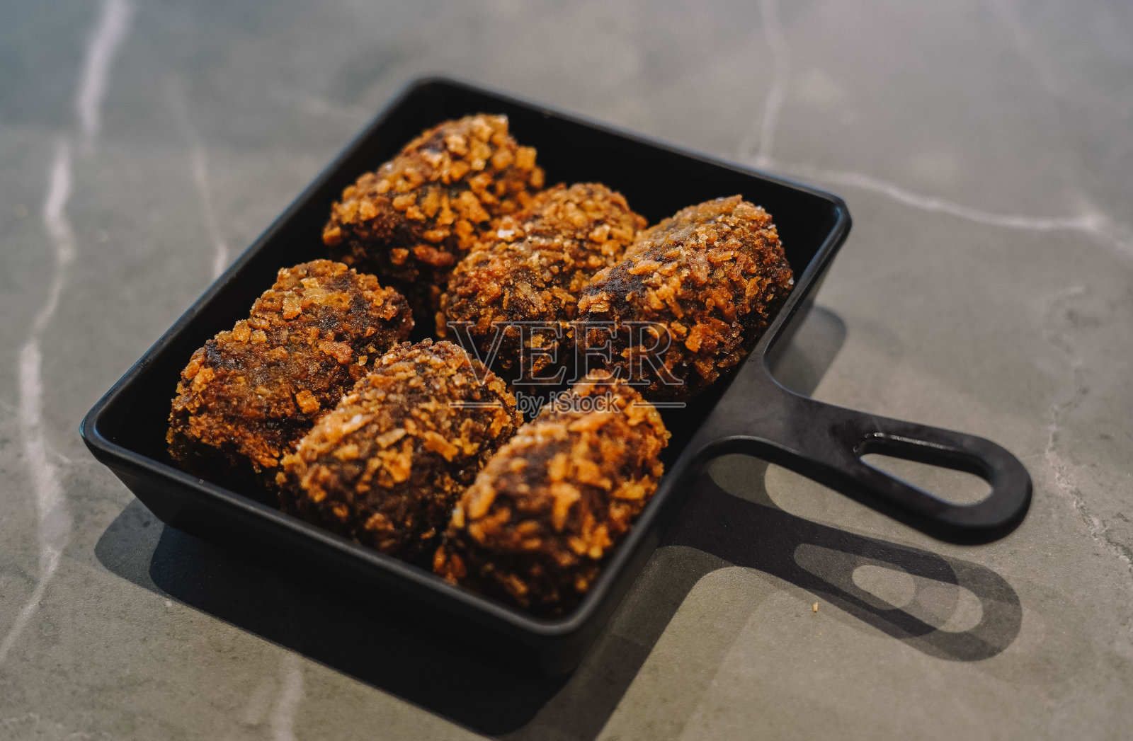 黑色盘子里的炸鸡肉丸照片摄影图片