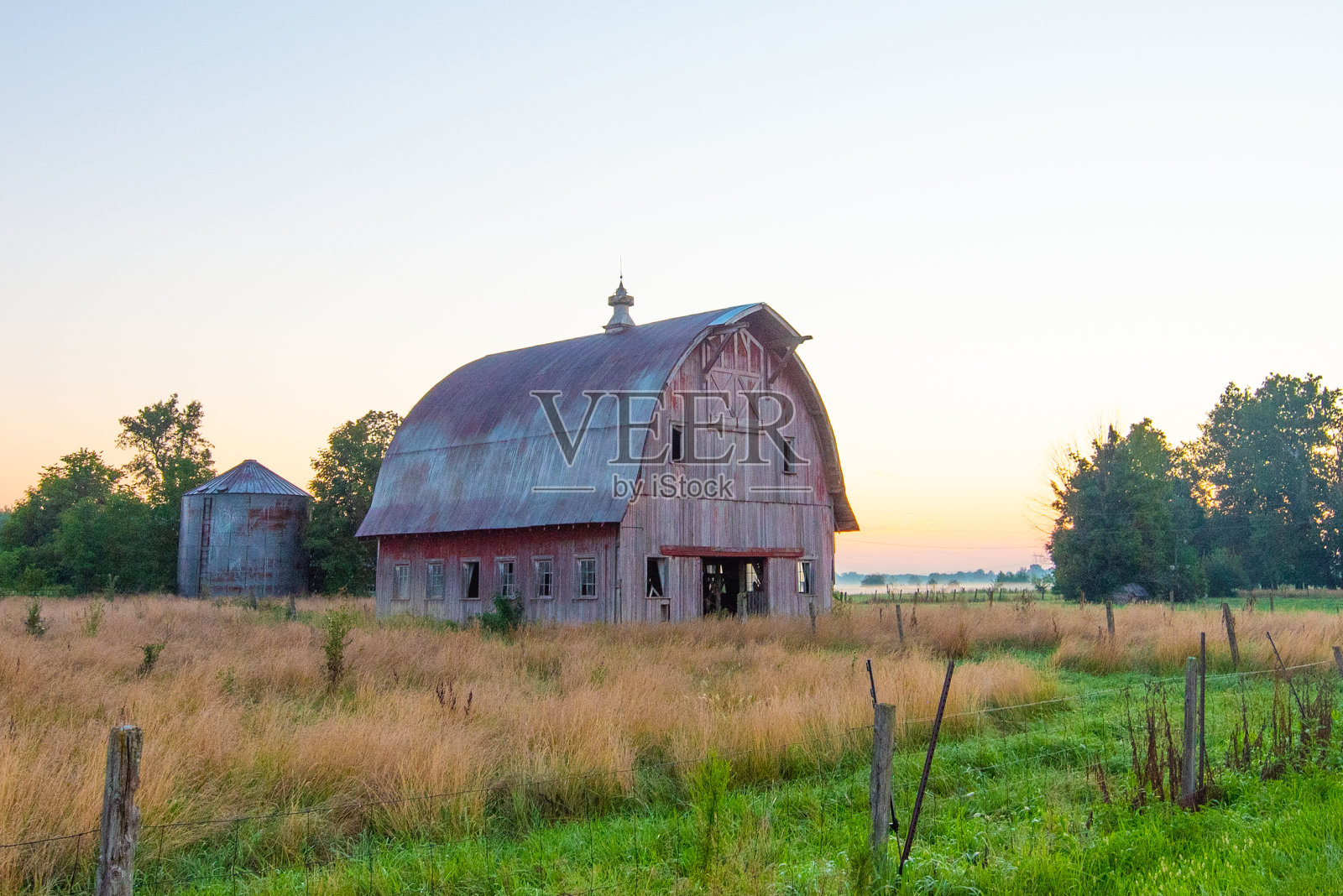 印第安纳州霍华德县日出时的旧风化红谷仓照片摄影图片