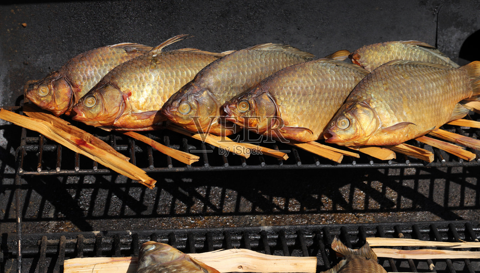 移动烟熏小屋里的熏鱼。照片摄影图片