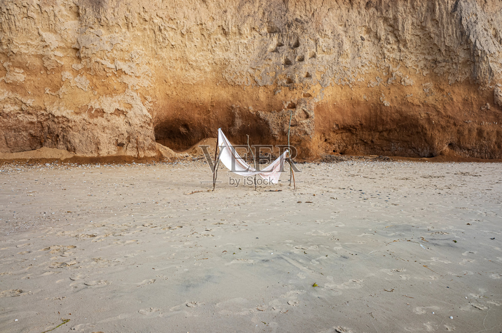 用树枝和织物制成的手工帐篷，可以在岸边遮挡阳光。照片摄影图片