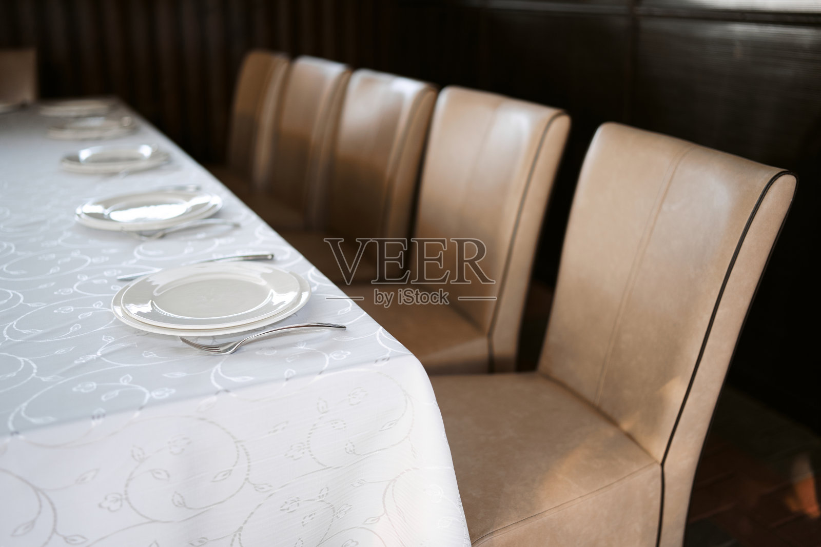 宴会桌在餐厅，宴会前的准备工作。专业花匠的工作。宴席:为宴会或婚宴准备的餐桌宴会桌设计照片摄影图片