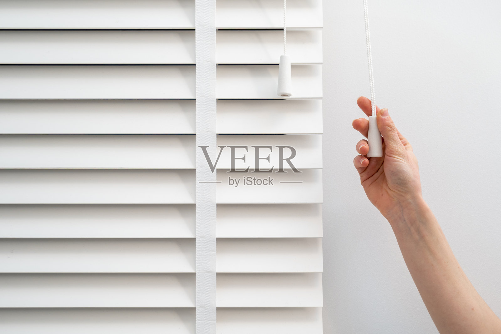 女士在百叶处调节遮光照片摄影图片