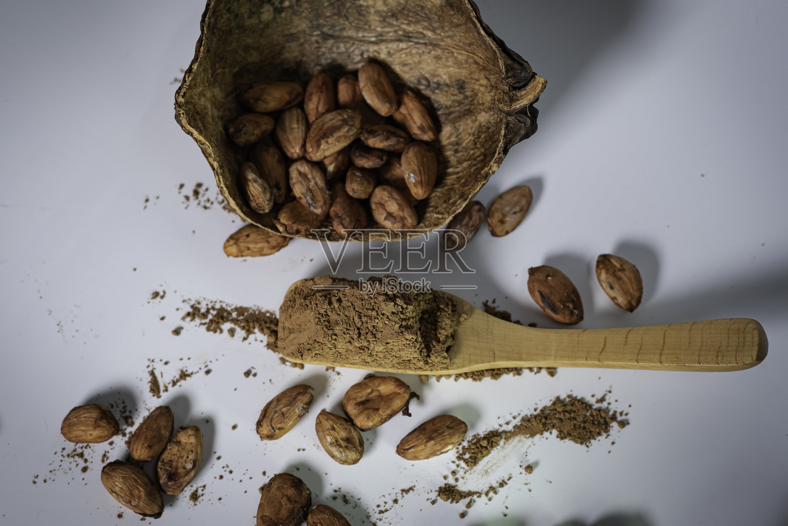 可可粉和可可豆放在白色的桌子上。照片摄影图片