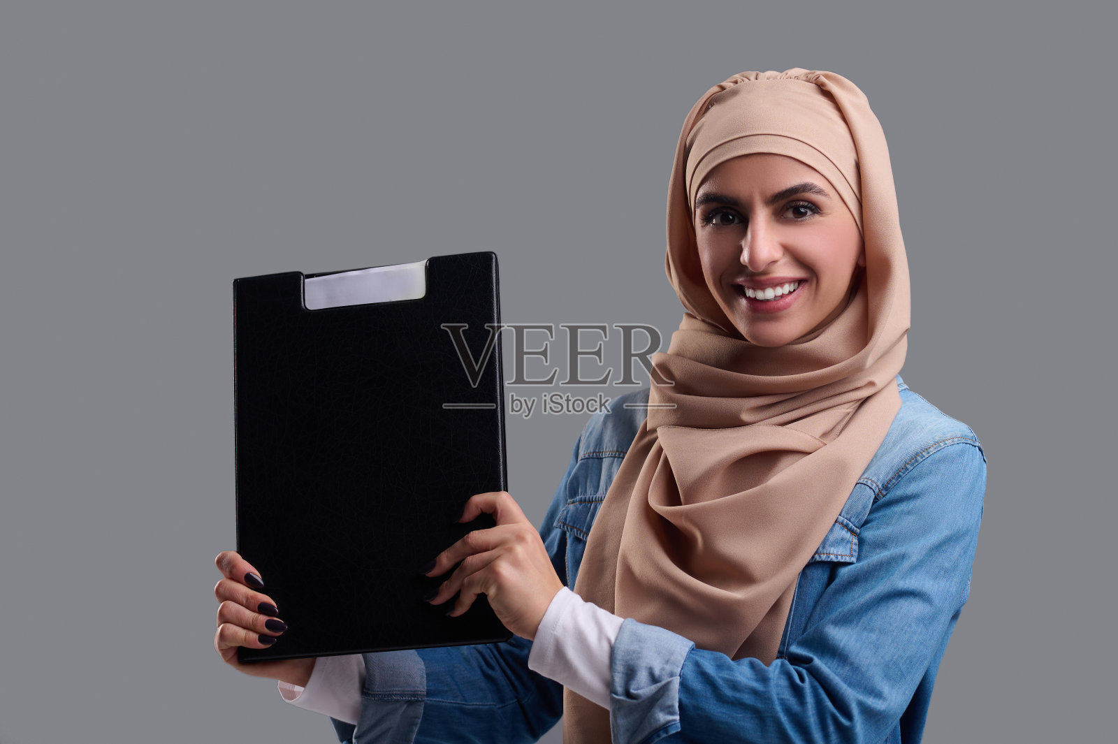 阿拉伯年轻女子米色头巾看起来快乐和满足照片摄影图片