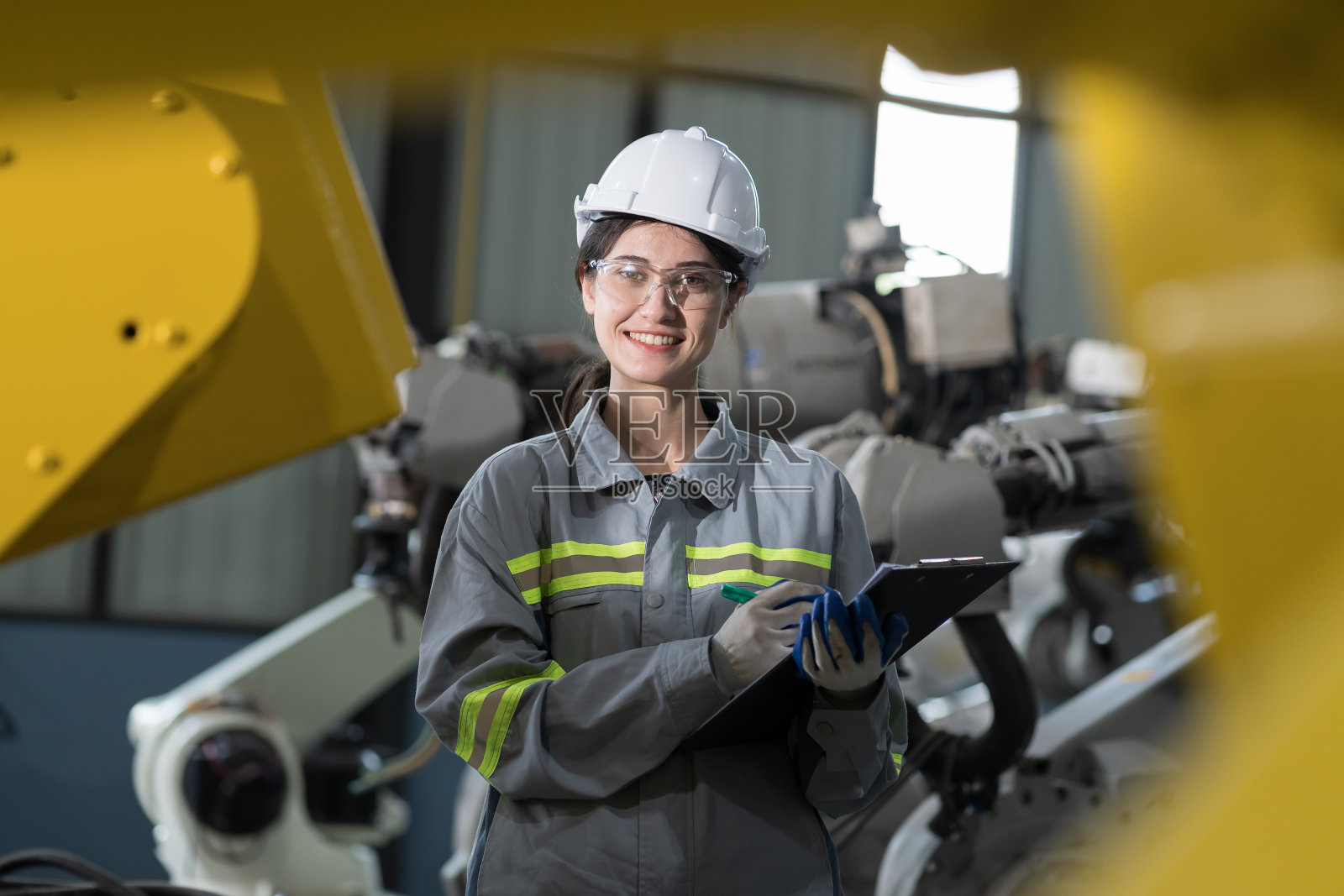 自动化制造业。女工程师检查、维修、维护车间生产线的自主机器人臂。创新科技理念照片摄影图片