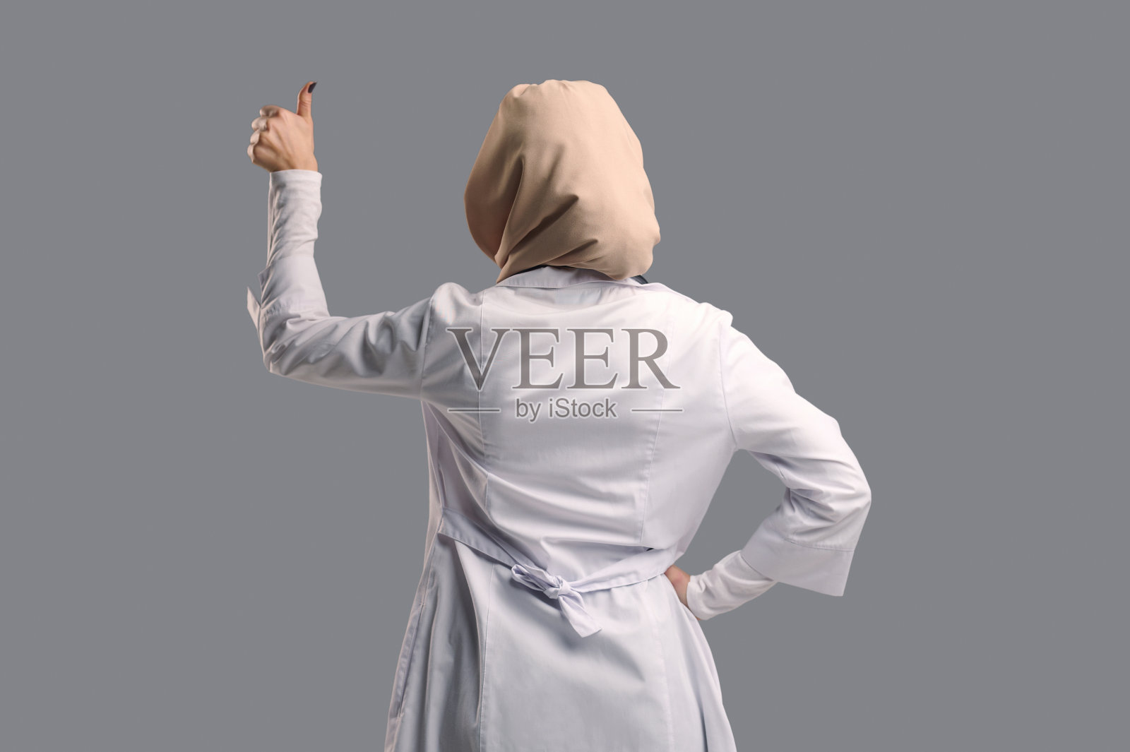 戴头巾穿白大褂的女人站在后面照片摄影图片