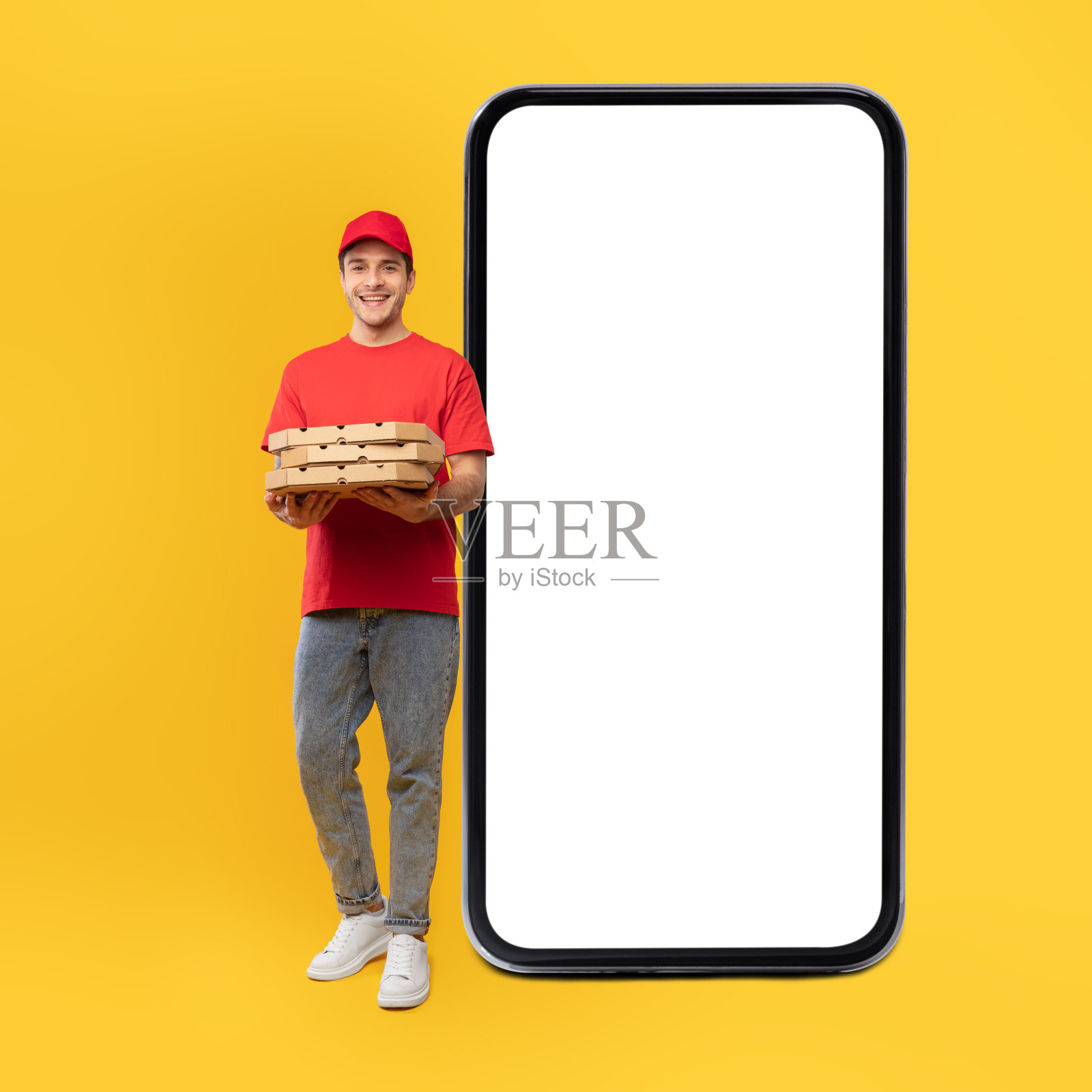快递员在大手机附近摆披萨盒，工作室照片摄影图片