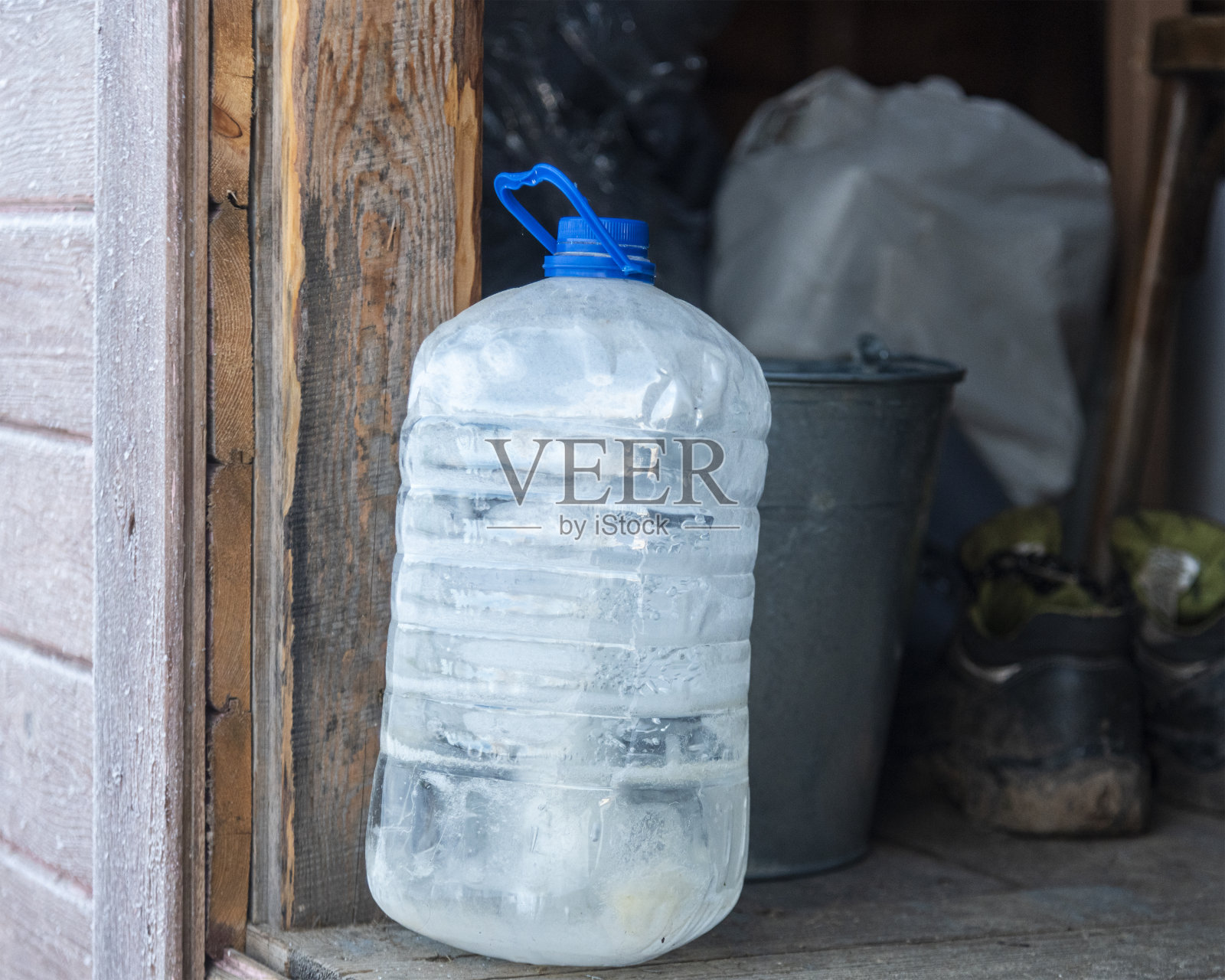 冰冻的水装在装满水的塑料瓶里，在严寒的棚子里照片摄影图片