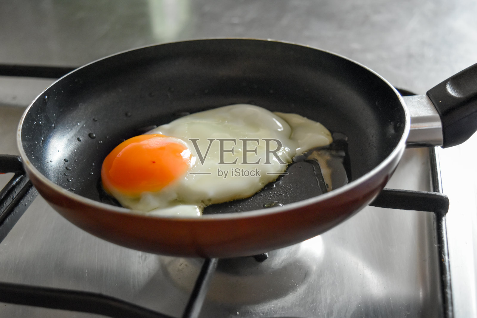 图为在厨房里煎鸡蛋准备早餐的女性手画。照片摄影图片