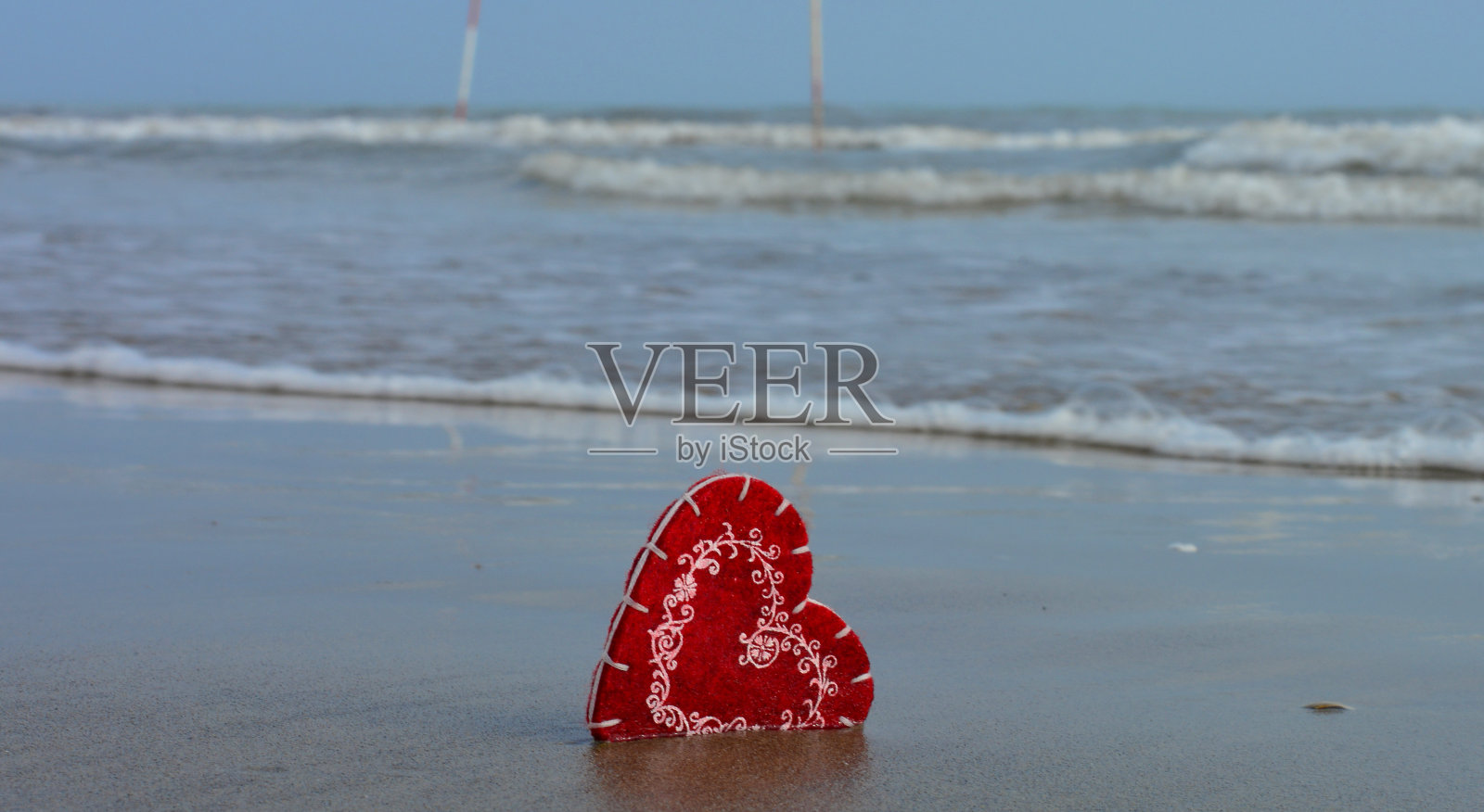一颗心在沙滩前的海浪照片摄影图片