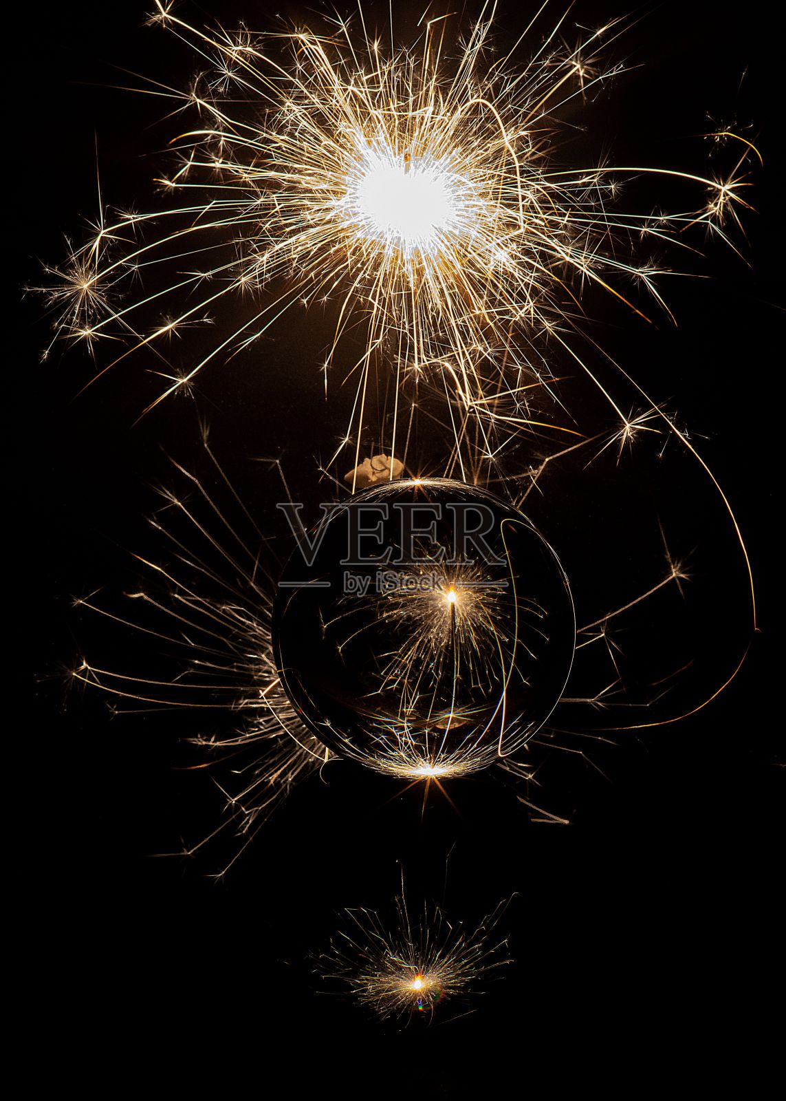 垂直拍摄的一个反射玻璃球在爆炸的彩色烟花前照片摄影图片