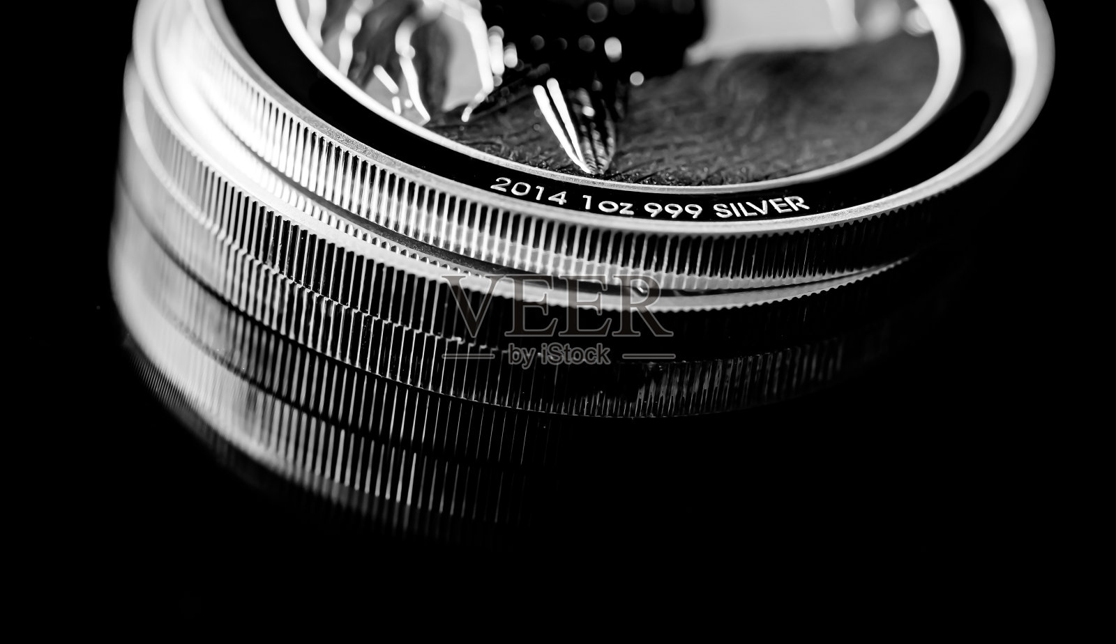 在黑镜背景上的银币特写照片摄影图片