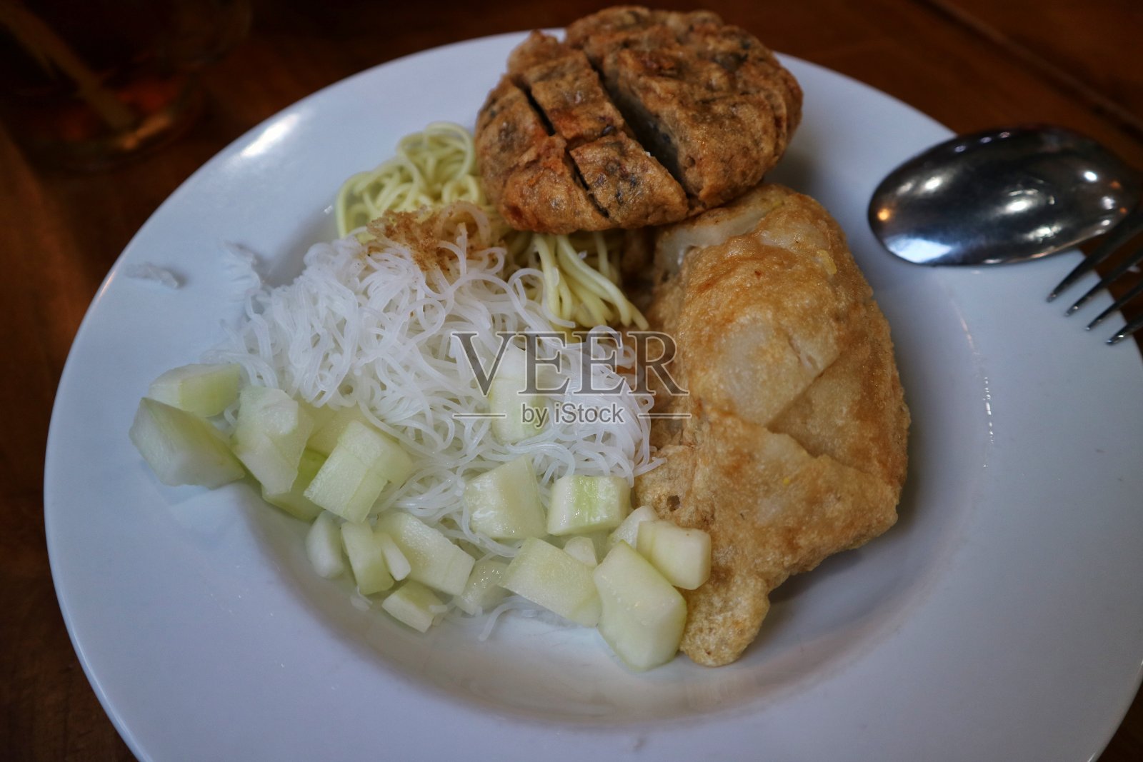 白色盘子里的鱼饼配粉丝和cuko酱。鱼饼是来自印度尼西亚南苏门答腊省巨港市的美味印尼鱼饼，由鱼和木薯制成。照片摄影图片