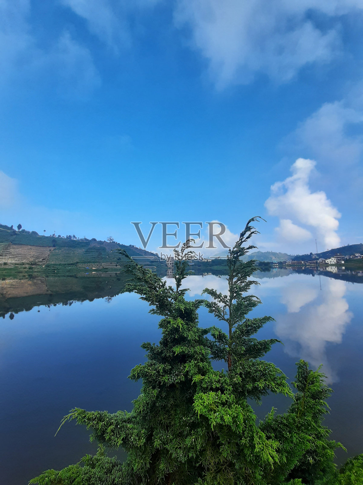 蓝色的湖，背景是小山照片摄影图片