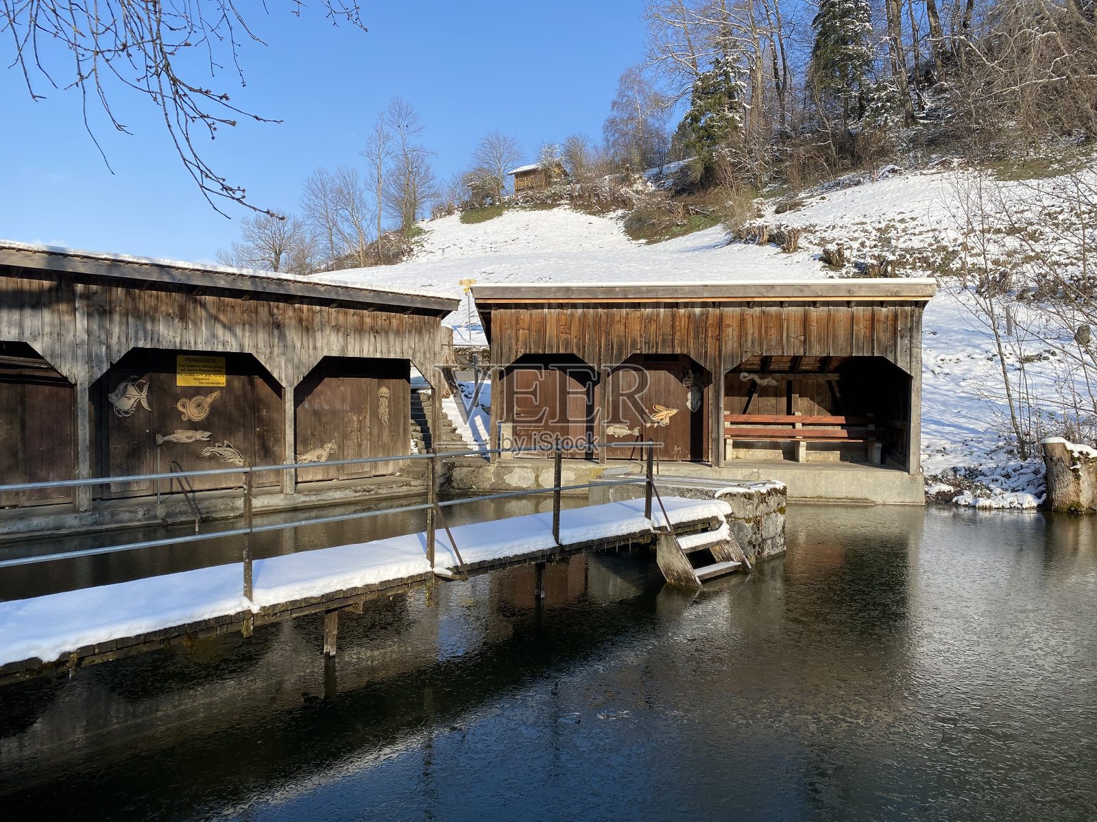 初春，最后一场雪落在阿尔卑斯山脉山坡上的小浴池巴德威厄湖上，覆盖着瑞士奥伯托根堡-内斯劳的阿尔卑斯山谷照片摄影图片