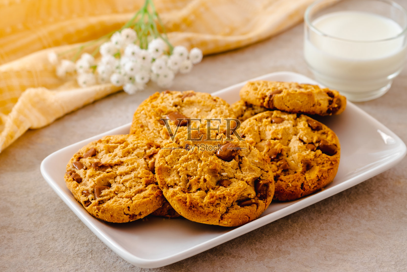 白色盘子里的巧克力饼干和一杯牛奶照片摄影图片