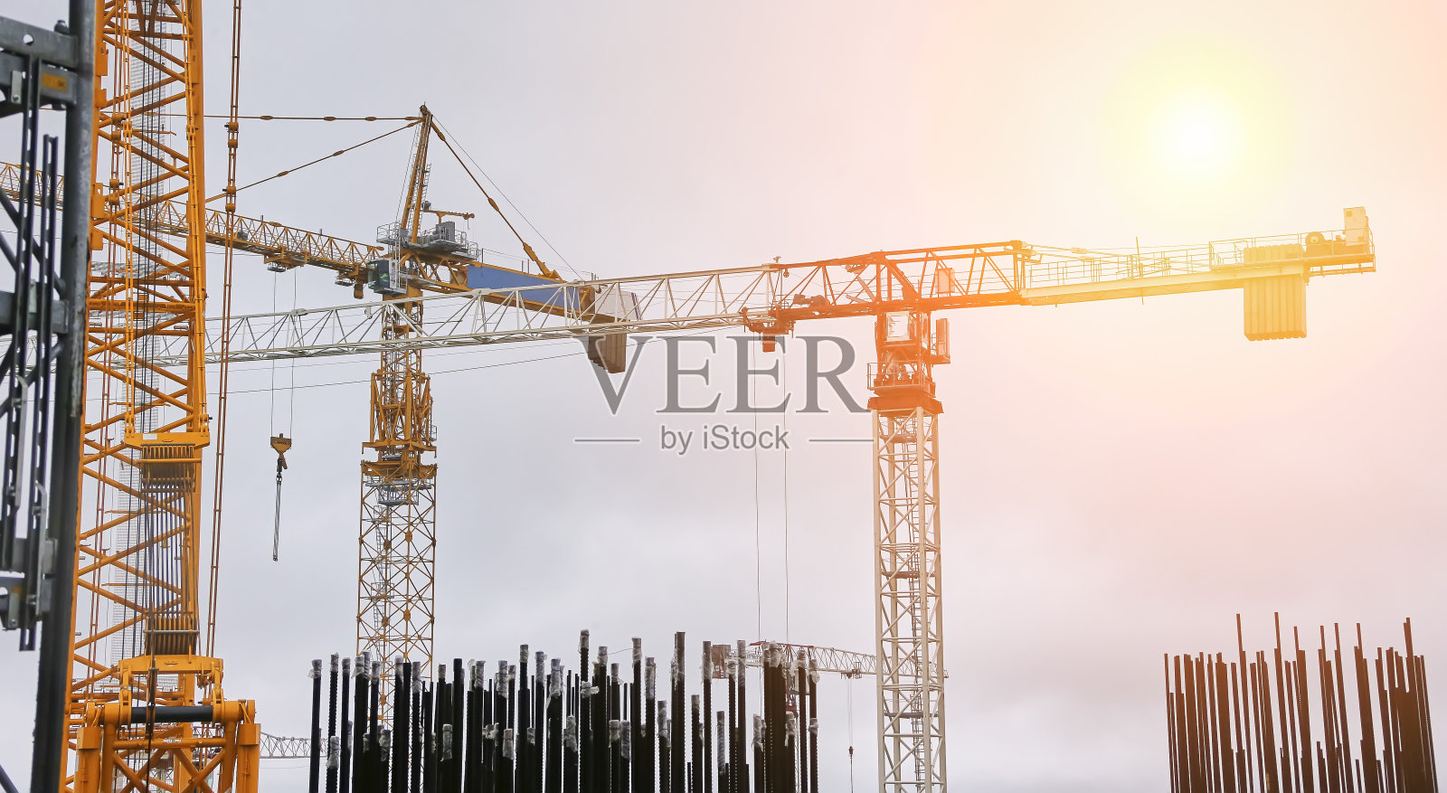 塔式起重机以冷却塔为背景。照片摄影图片