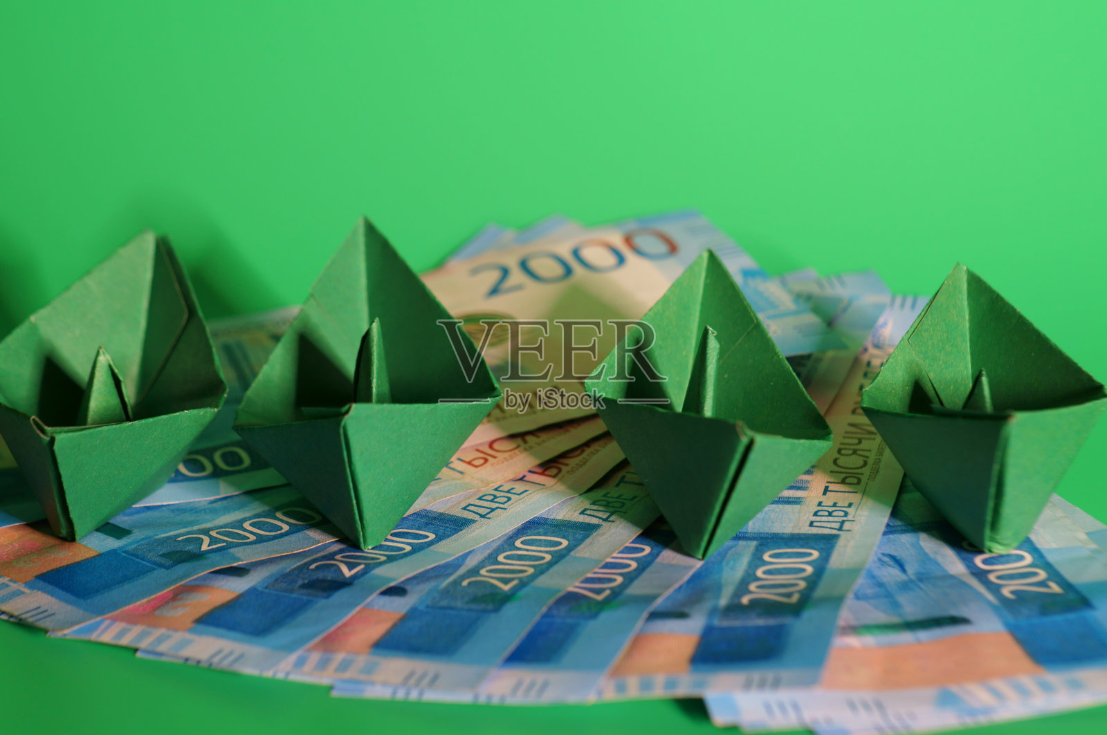 绿色背景上的一组折纸船和纸币。业务概念。照片摄影图片