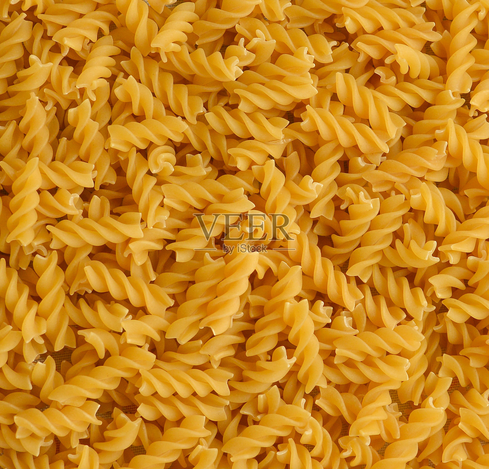 福西利背景。一堆生的意大利意大利面。照片摄影图片