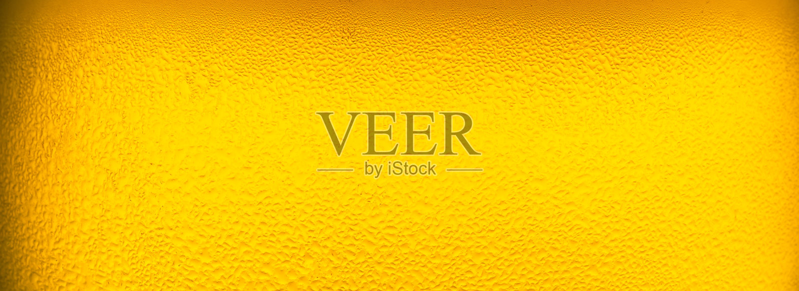 宏观啤酒玻璃背景，在玻璃中倒入带有泡沫的啤酒作为背景和设计。照片摄影图片