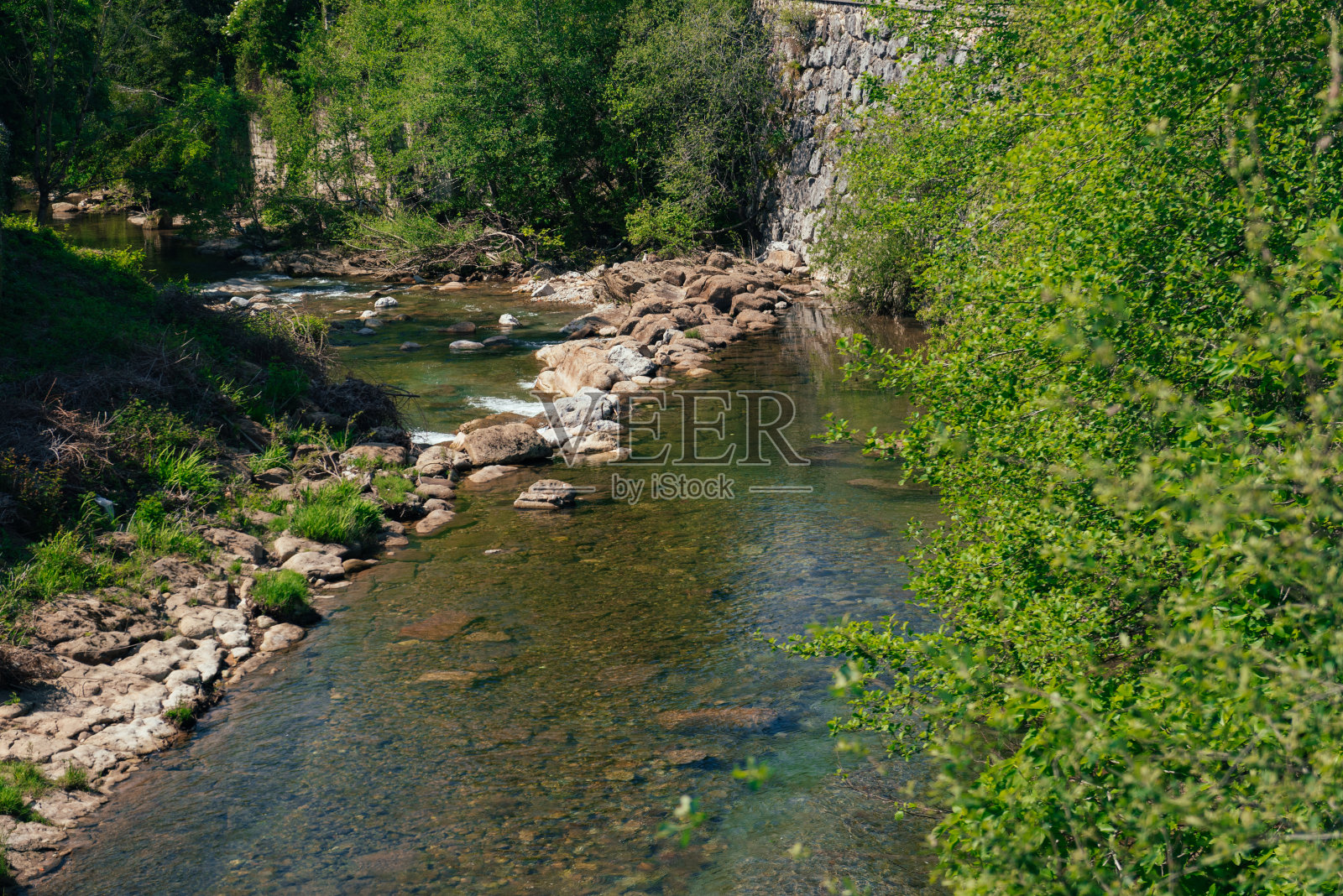 一条浅河从石桥下流过。照片摄影图片
