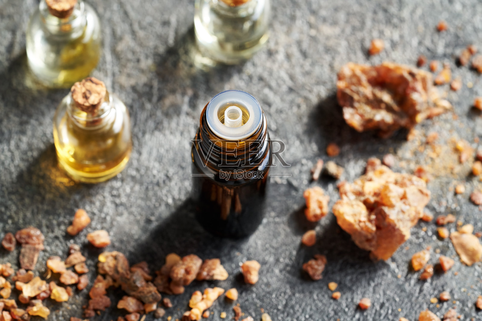 一瓶深色的精油和没药树脂照片摄影图片