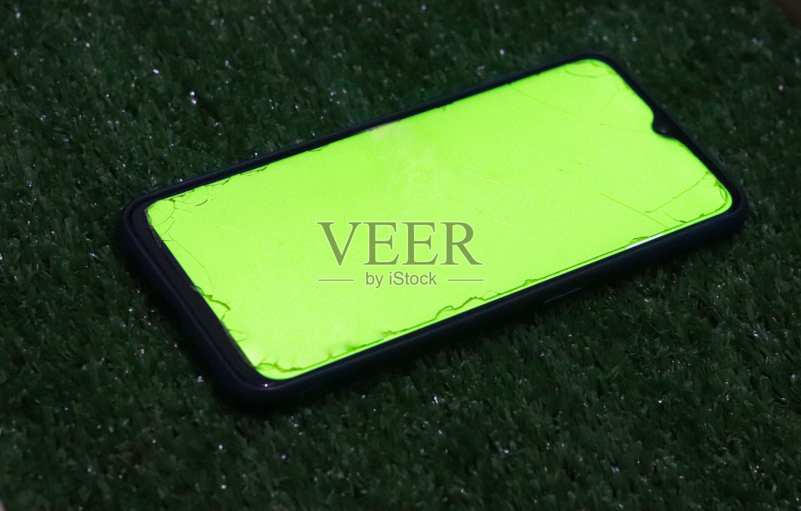 绿屏手机，草地背景照片摄影图片