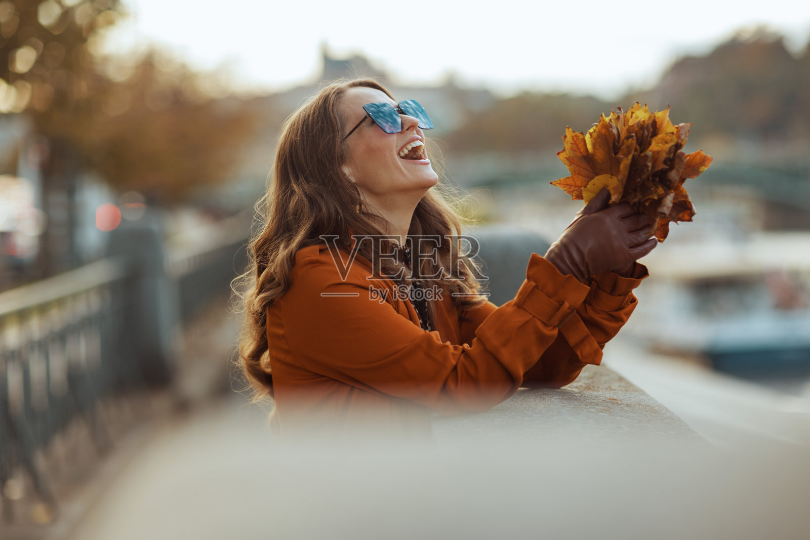 穿着棕色风衣的快乐女人照片摄影图片
