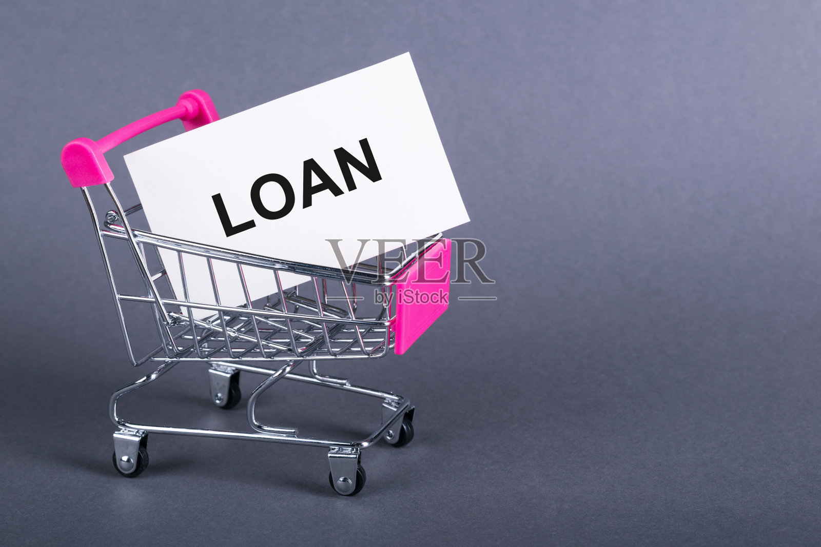 白纸卡与贷款文本在一个深灰色背景的购物车。照片摄影图片