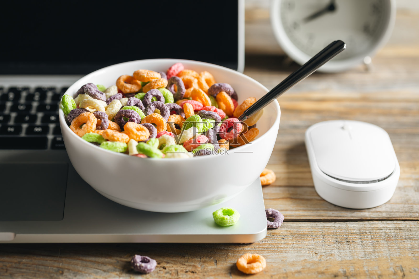 彩色早餐麦片放在碗里和笔记本电脑，健康早餐近在咫尺。照片摄影图片