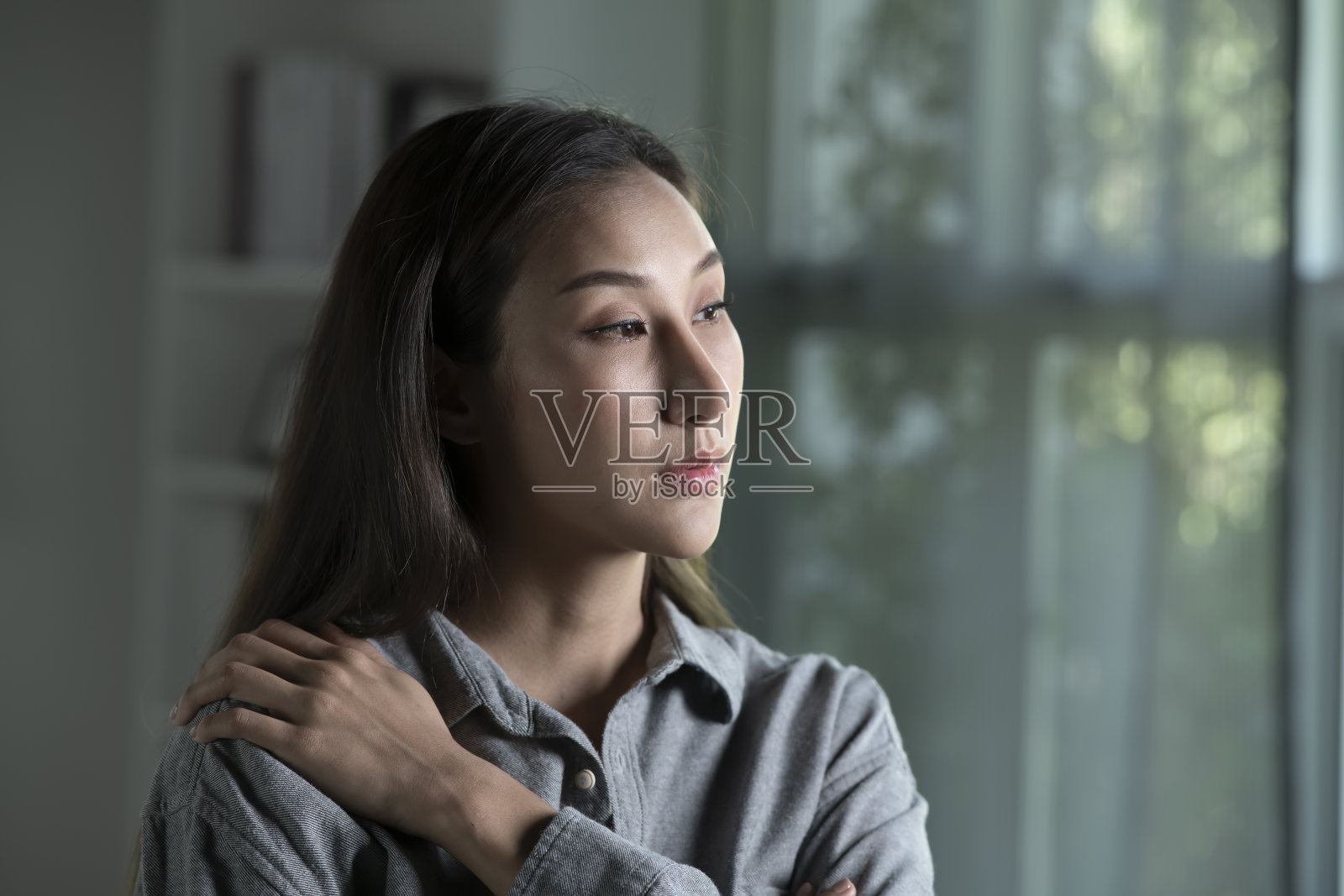客厅里悲伤而焦虑的年轻亚洲女人的肖像照片摄影图片