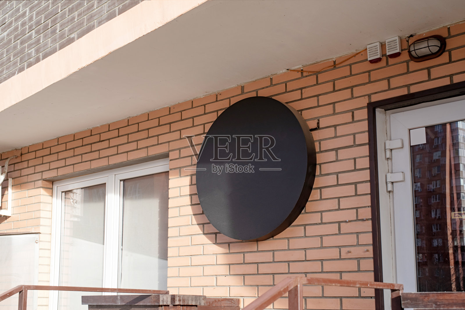 黑色圆形标志在砖墙建筑外观的模型设计照片摄影图片