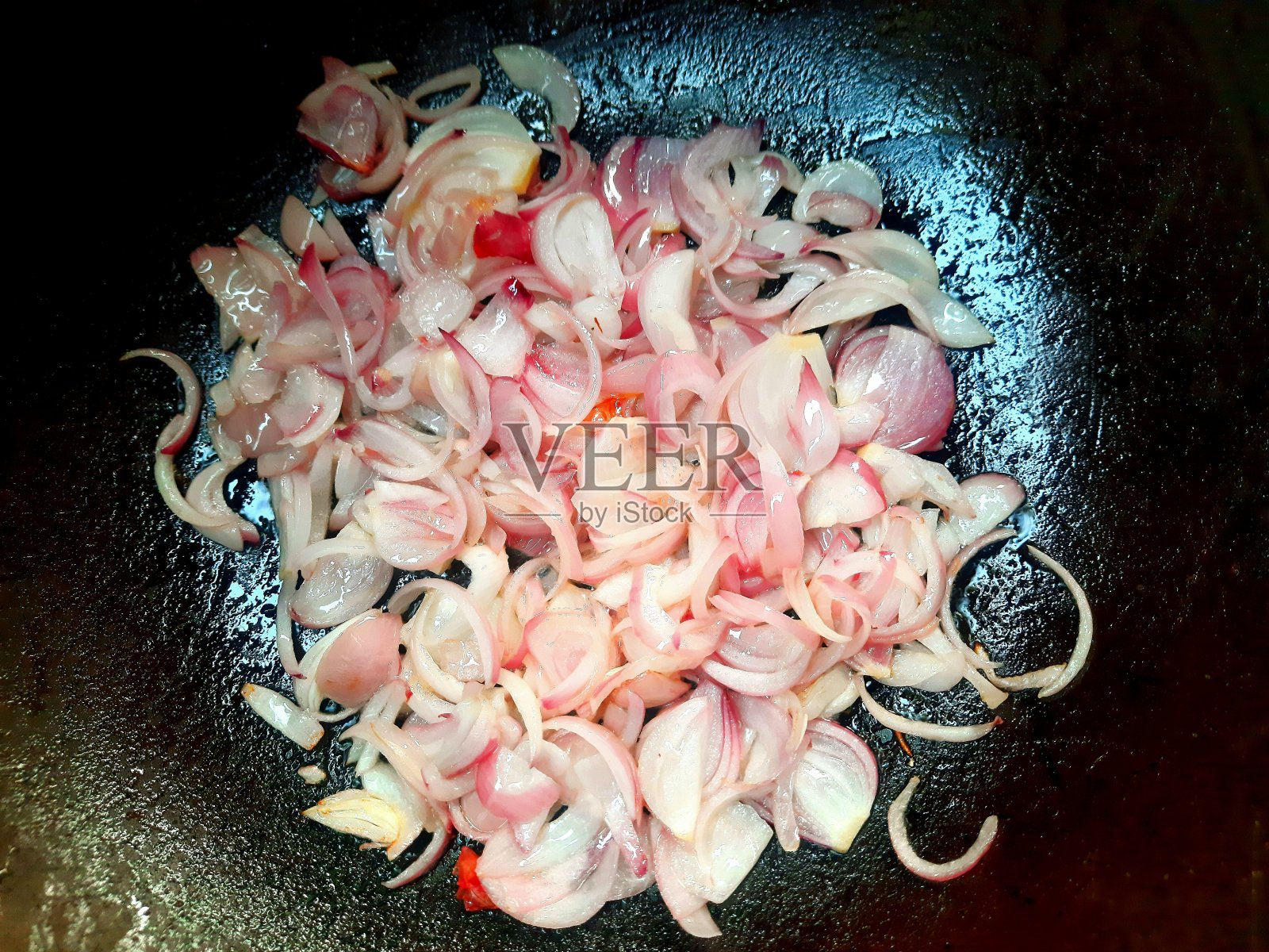 用煎锅煎碎红洋葱。照片摄影图片