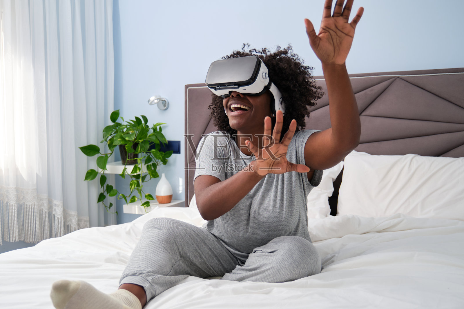 年轻非洲女性在床上体验沉浸式VR照片摄影图片