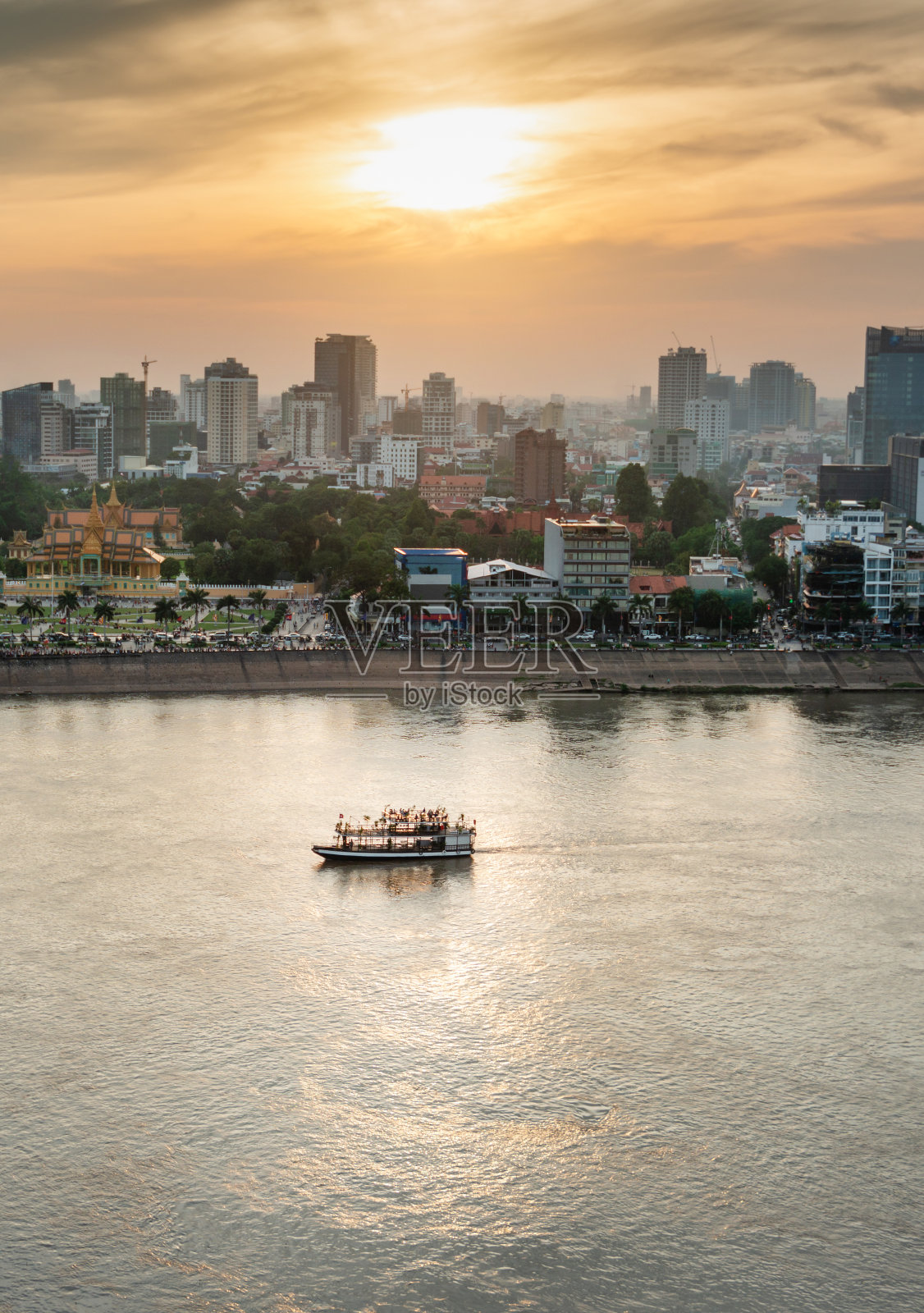 从柬埔寨洞里萨湖东岸观看日落时的金边河游船。照片摄影图片
