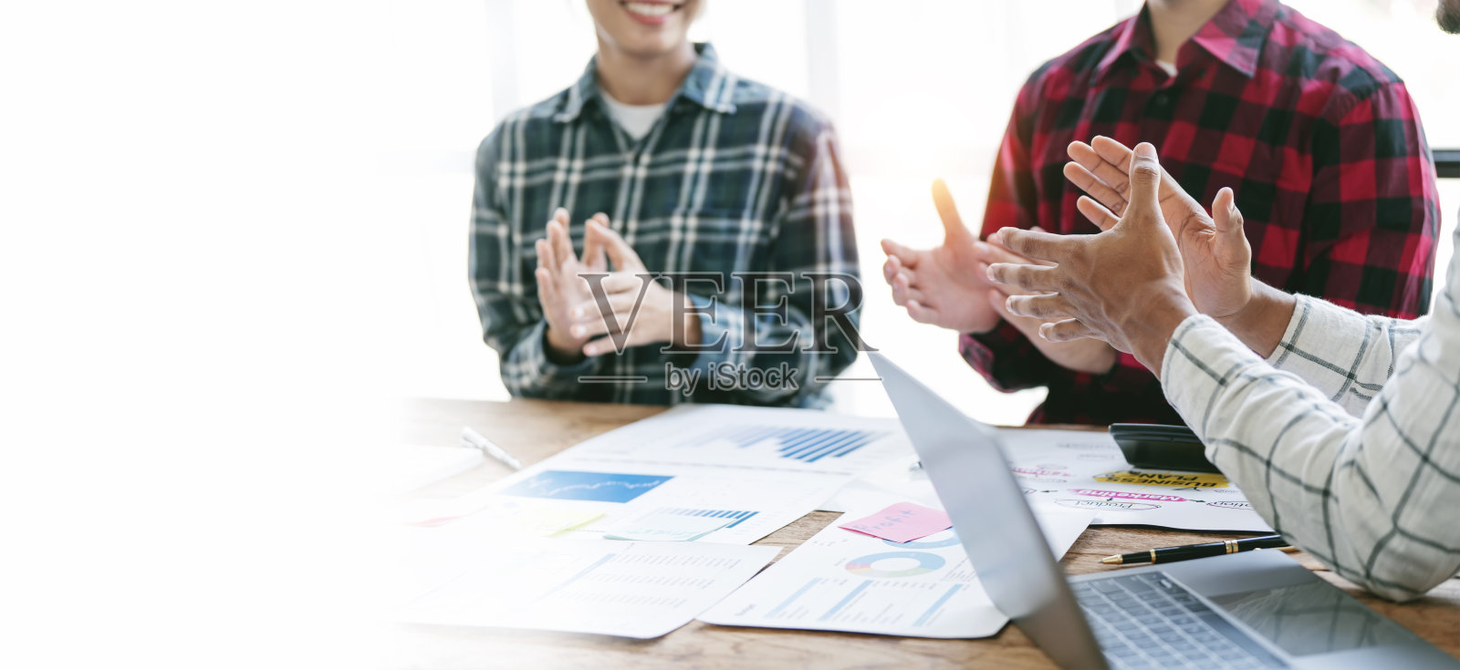 商界人士在鼓掌。一群商务人士坐在办公桌旁鼓掌。横幅背景。照片摄影图片